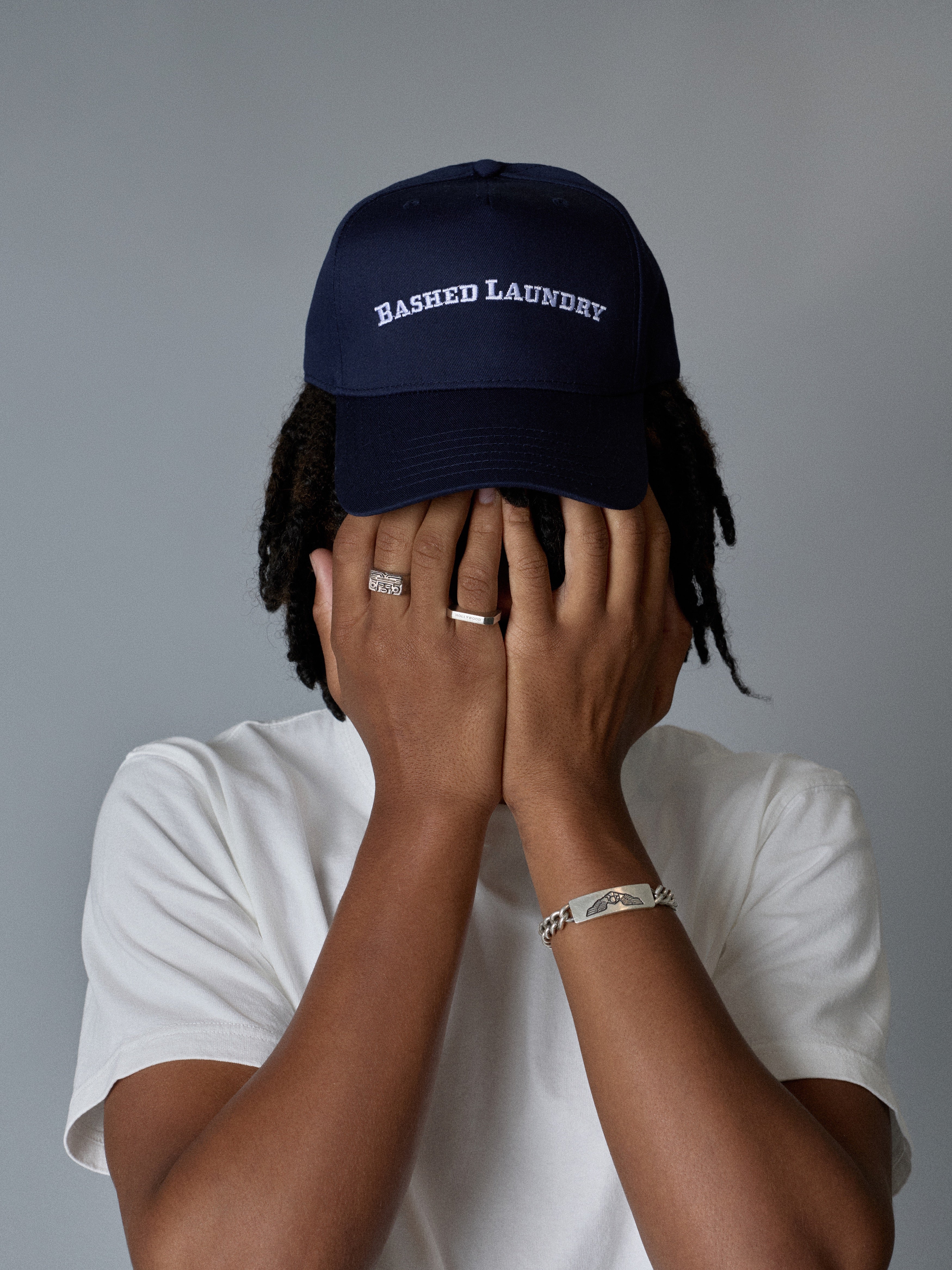 Men’s and unisex ink blue trucker hat with Bashed Laundry embroidery, front view